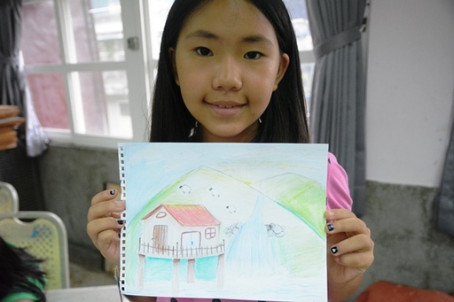 孩童展示繪畫作品，分享創作想法。孩在延平/提