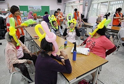 圖為龍華科大原民學生志工團,前往花蓮撒固兒部落返鄉服務,部落長輩們做氣球笑開懷。