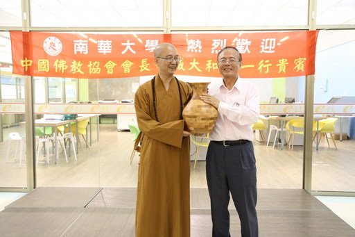 中國佛教協會會長學誠大和尚一行蒞南華大學參訪,林聰明校長(右)致贈創意產品設計學系精心製作的木製拼接花瓶予學誠大和尚(左)。