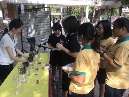 新聞圖說3:師生聚集於展示攤位前,觀察魚菜共生瓶。
