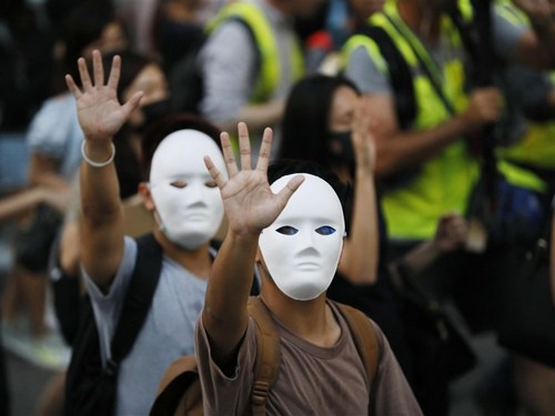 In face masks, Hong Kong people take to the streets Friday to protest the government’s decision to ban face masks in an attempt to quell mass demonstrations. (Photo courtesy of Kyodo News)
