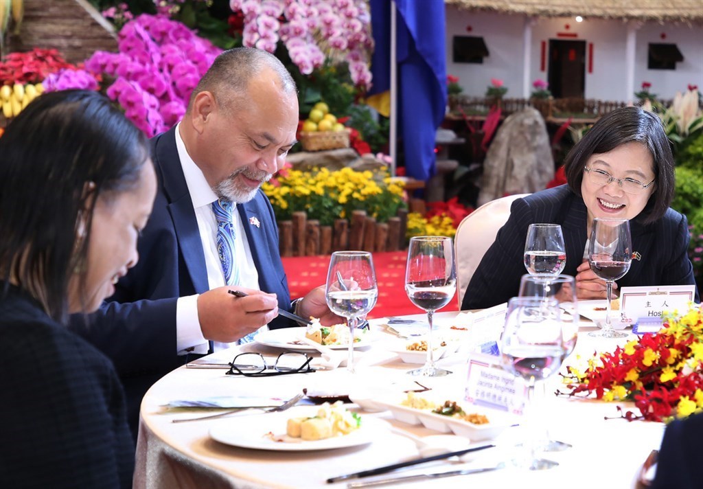 Nauru President Lionel Aingimea (center) tries a mild form of stinky tofu at Friday
