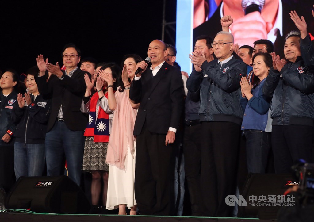Han Kuo-yu (fourth from right) speaks at the rally alongside his wife Lee Chia-fen (fifth from right), vice presidential candidate Chang San-cheng (third from left), KMT Chairman Wu Den-yih (third from right), New Taipei Mayor Hou You-yi (right) and Taichung Mayor Lu Shiow-yen (second from left).