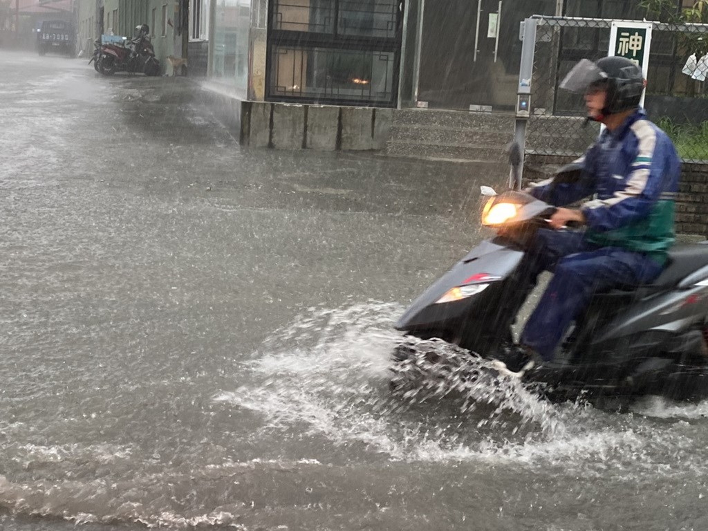 A man rides his scooter through streets flooded by torrential rain in Kaohsiung Friday. (Photo provided by a member of the public)