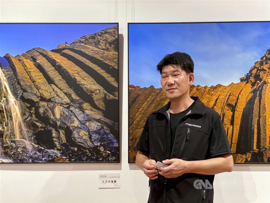 Taiwanese photographer Lee Ming-tsung (李明宗) stands besides his works exhibited at National Dr. Sun Yat-sen Memorial Hall in Taipei