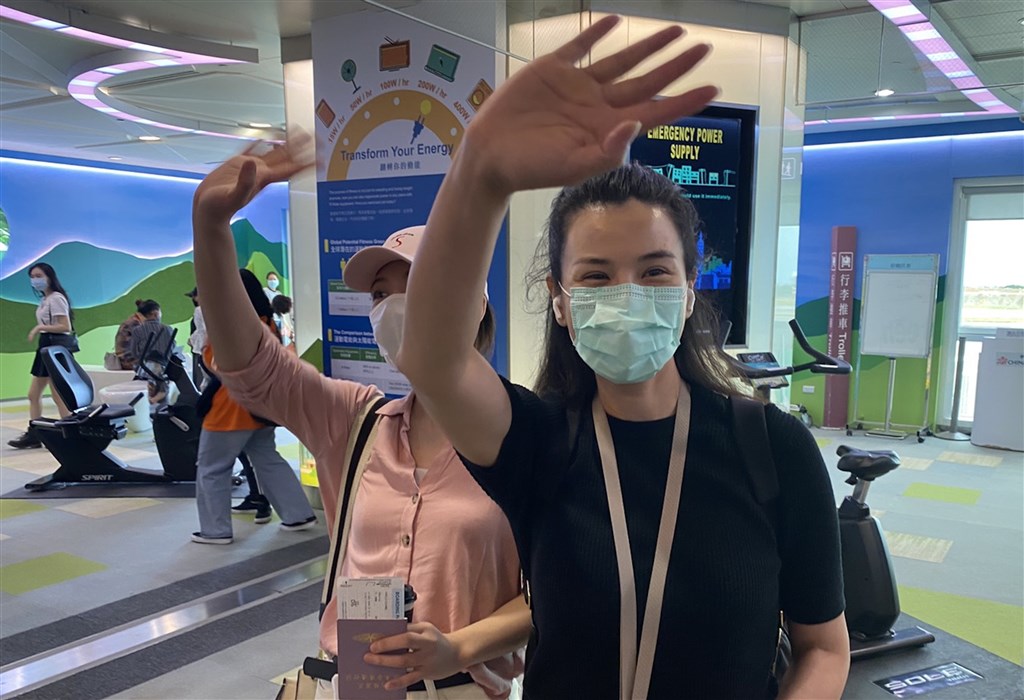 The two Chinese reporters wave goodbye at the airport.