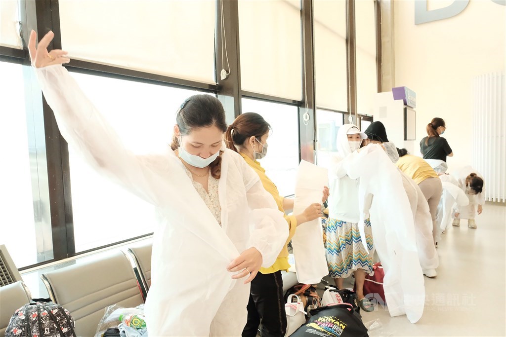 The Vietnamese passengers wear protective gowns before boarding the flight. CNA photo July 7, 2020
