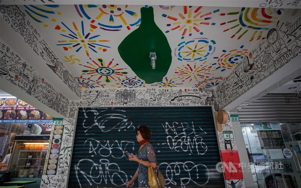 A woman walks past by a closed shop that was put up for rent in early July. CNA file photo