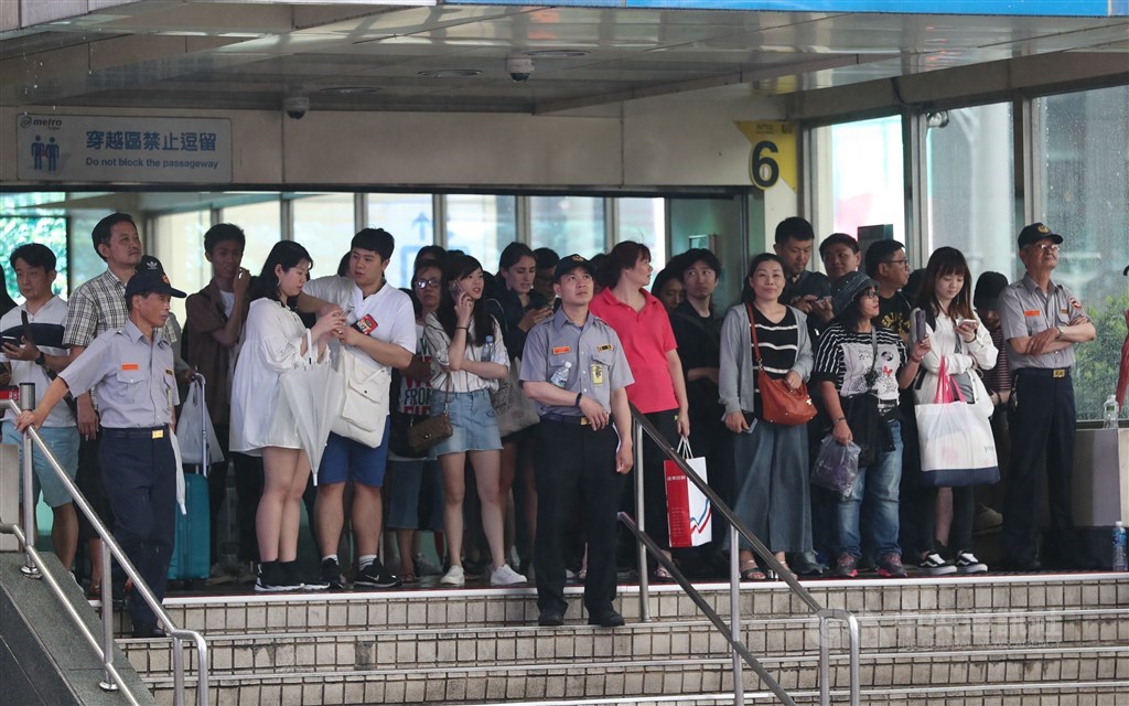 Police officers hold crowds at an exit of Taipei
