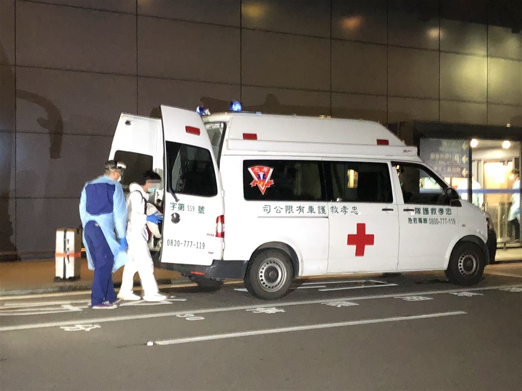 The passenger with a fever (in white) boarding an ambulance that will take him to the hospital. CNA photo Dec. 27, 2020