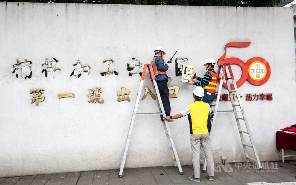 Workers take off a sign reading "Nanzih Export Processing Zone" ahead of the name change. CNA photo Feb. 24, 2021