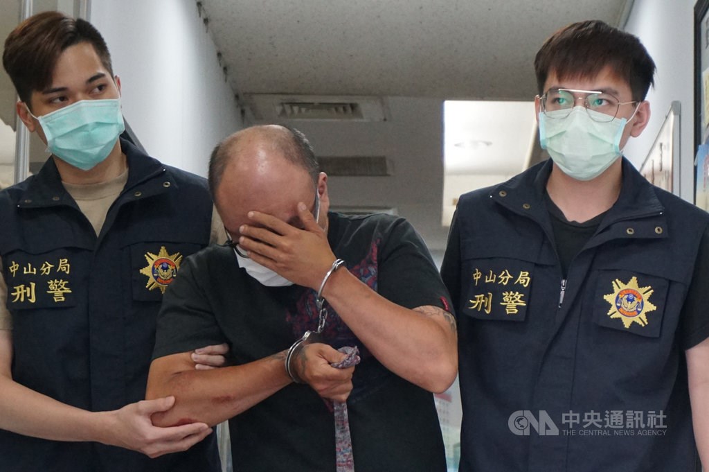 A 36-year-old Taiwanese food delivery worker (center), the main suspect in the death a Vietnamese woman in Taipei, steps out of a police station Thursday. CNA photo May 13, 2021
