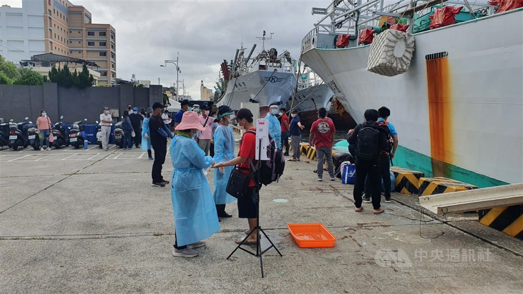 Fishermen are greeted by medical workers on arrival in Kaohsiung Tuesday. CNA photo June 15, 2021