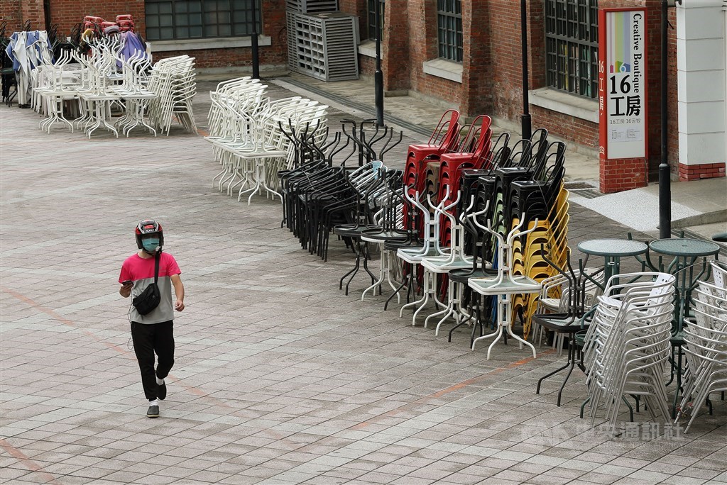 A food delivery worker walks through what used to be a open air bar area in Taipei