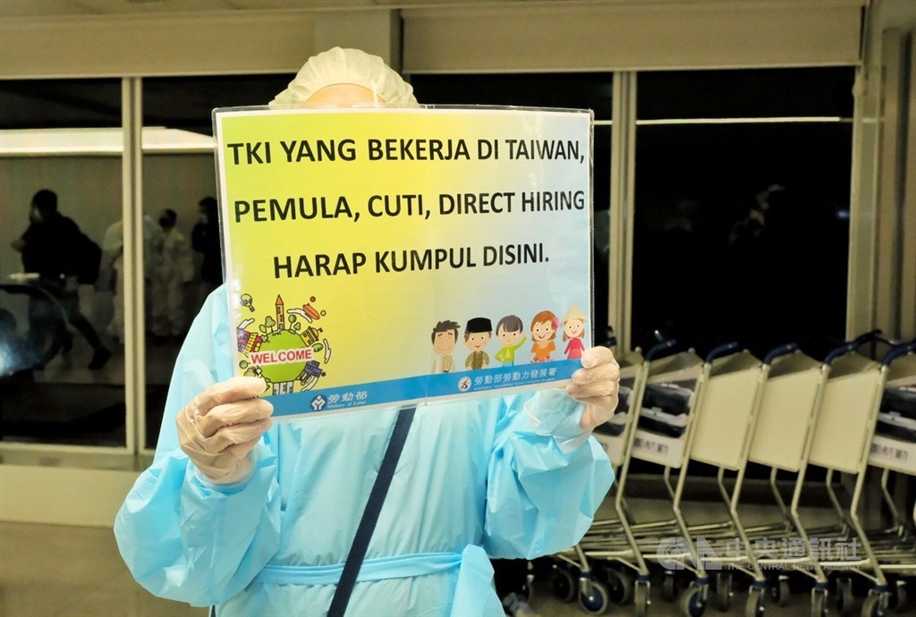 A Workforce Development Agency official holds a card in Indonesian to greet arriving workers. CNA photo Nov. 17, 2021