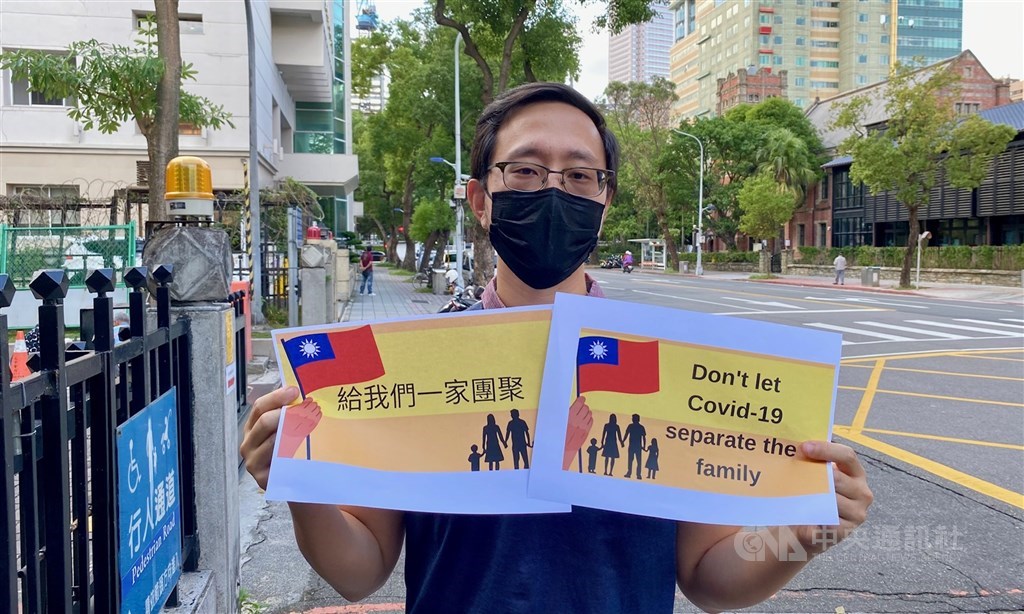 An American man, identified as Alvin, holds signs outside the Bureau of Consular Affairs in Taipei to urge the government to allow his wife to enter Taiwan so that they can be reunited. CNA photo Nov. 19, 2021