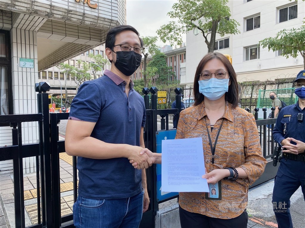 Pauline Chen (right) receives the petition from Alvin. CNA photo Nov. 19, 2021