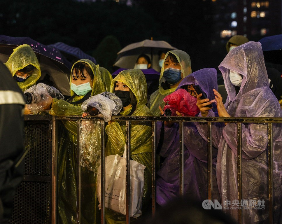 Fans wait outside the venue in the rain to see stars on the red carpet. CNA photo Nov. 27, 2021