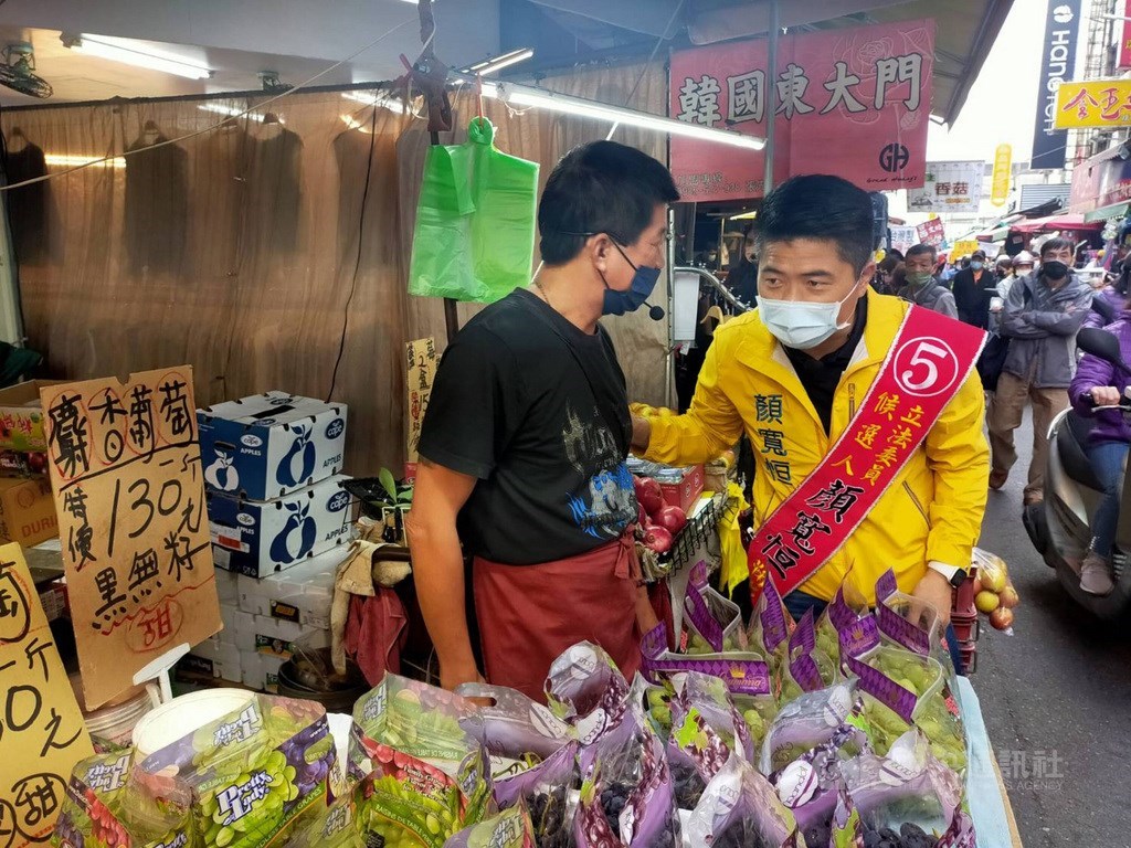 KMT candidate in the Jan. 9 by-election (right) campaigns at a local market in Taichung Friday. CNA photo Dec. 17, 2021