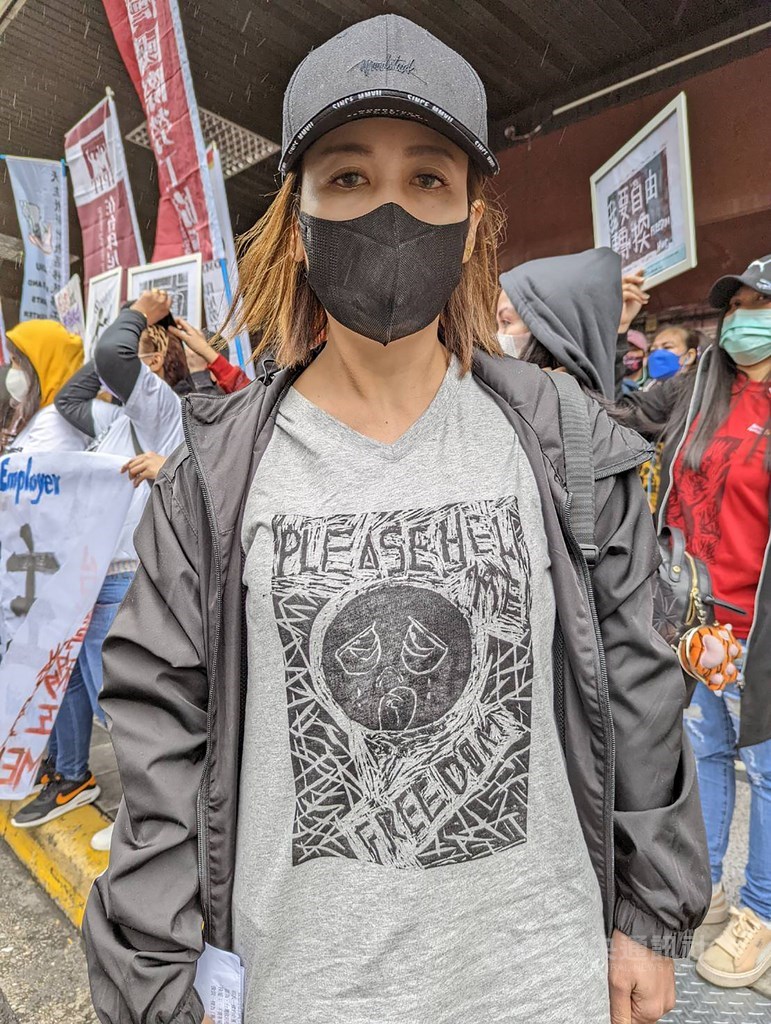 Ani, a caretaker from Indonesia, wears a T-shirt printed with a crying face she created to express her fear and call for help. CNA photo Dec. 26, 2021