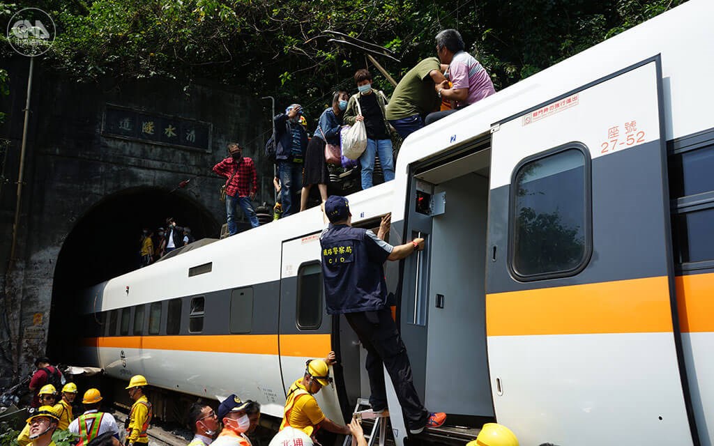 Passengers climb to the top of a Taroko Express train after it slammed into a crane truck as it was entering a tunnel in Hualien County, causing it to partially derail, on April 2.