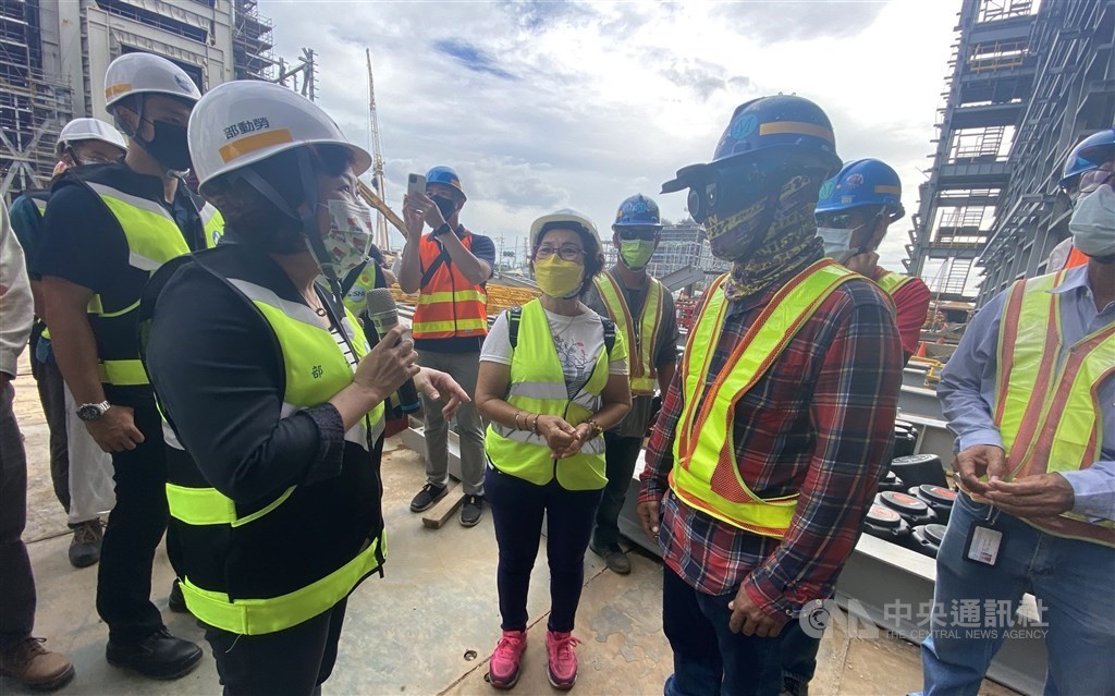 Minister of Labor Hsu Ming-chun (left) chats with a migrant worker during an inspection of a construction site in Taoyuan in October. CNA file photo