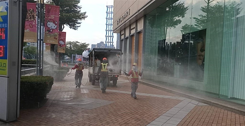 Kaohsiung City government workers on Tuesday disinfect around a shopping mall visited by a family from Taoyuan after the mother and a child were confirmed to have COVID-19. Photo courtesy of Kaohsiung City Environmental Protection Bureau