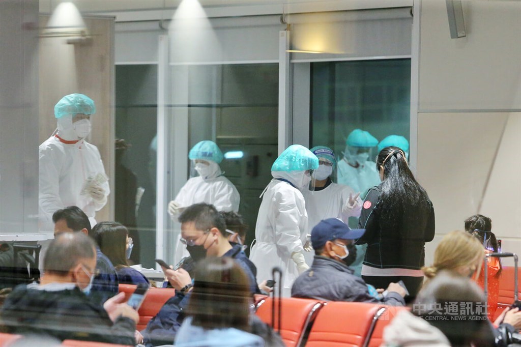 Passengers arriving on a long-haul flight are being processed and wait for their COVID-19 test results by the gate at Taiwan International Airport on Wednesday. CNA photo Jan. 12, 2022