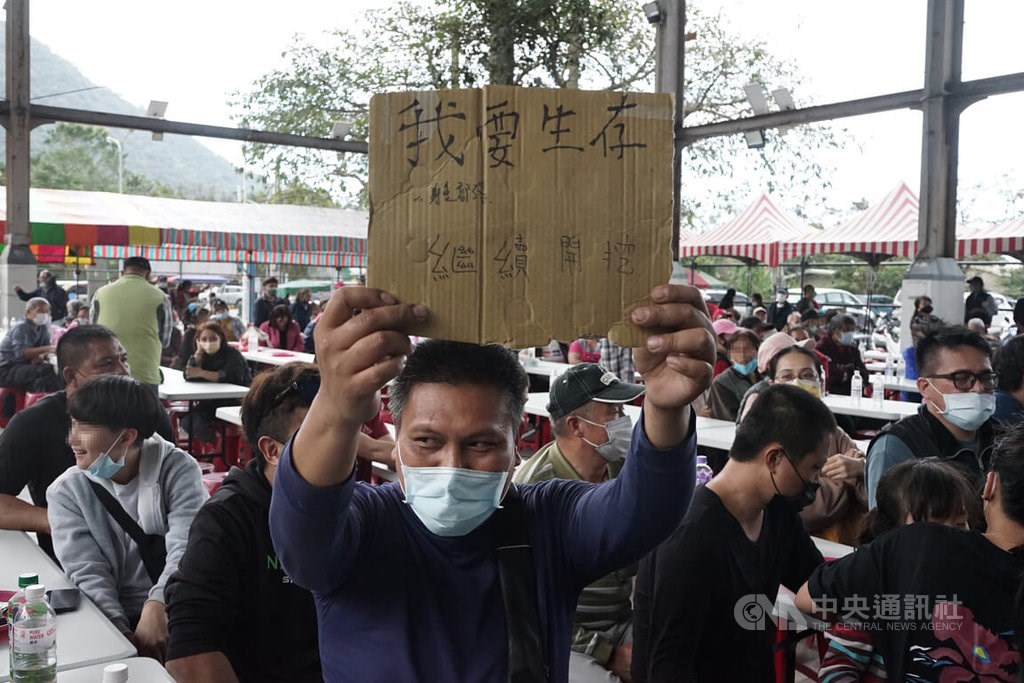 A voter in favor of extending the mining rights of Asia Cement Corp. holds up a placard reading "I want to survive." CNA photo Feb. 12, 2022