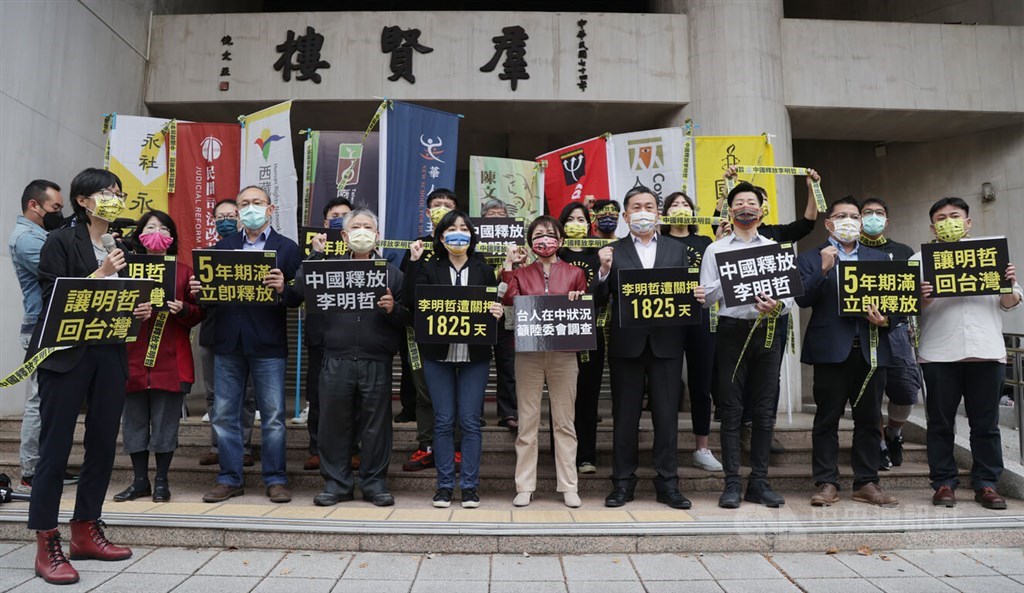 Members of human rights groups hold signs outside a building of the Legislature in Taipei, calling for the release of Taiwanese national Lee Ming-che. CNA photo March 18, 2022