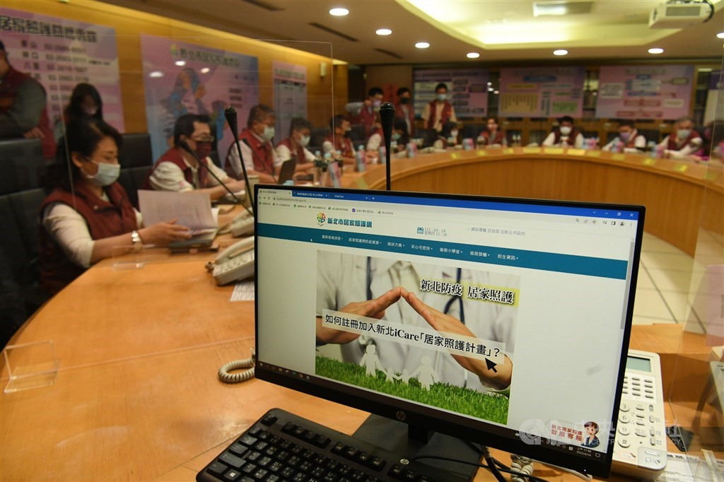 A task force and a computer displaying the website New Taipei City government set up to look after mild COVID-19 cases isolated at home. CNA photo April 14, 2022