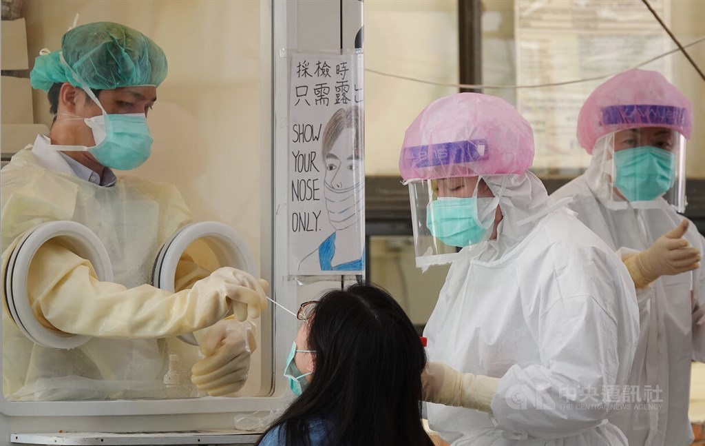 A woman is swabbed by medical workers for a COVID-19 test at Taipei City Hospital