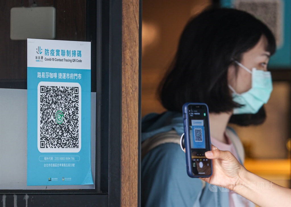 A customer scan a QR code before entering a coffee shop in Taipei Wednesday, when the CECC announced the elimination of the text message-based service as part of its plan to simplify contact tracing. CNA photo April 27, 2022