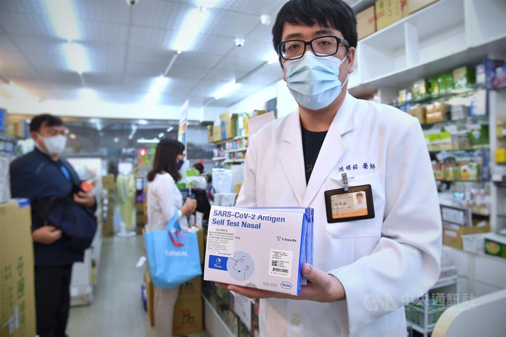 A pharmacist in Taipei displays the COVID-19 rapid test kits to be sold under the new rationing scheme that will begin on Thursday. CNA photo April 27, 2022