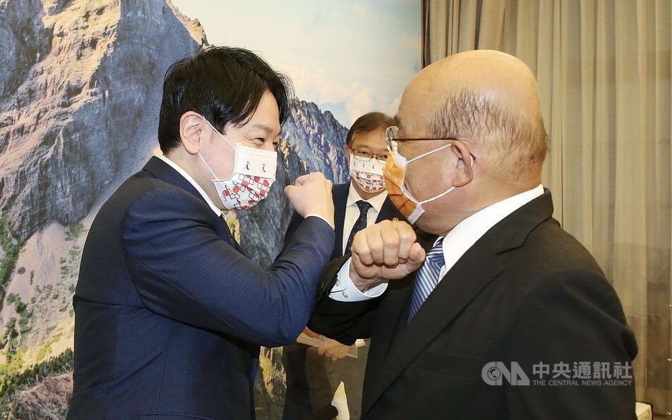 Premier Su Tseng-chang (left) greets Masanobu Ogura in Taipei with an elbow bump, when he received a delegation led by the member of Japan
