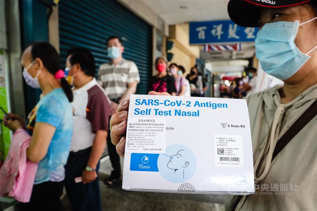 A resident in New Taipei shows a pack of rapid test kits sold through pharmacies under the government