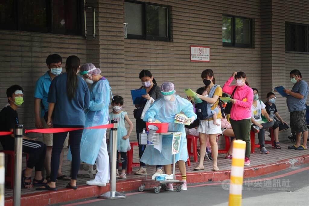 Parents and their kids wait in a line for dedicated testing service for children at Taipei Hospital in New Taipei