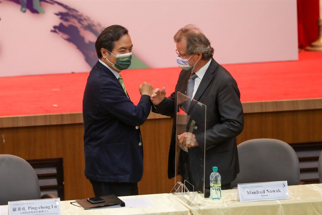 Cabinet spokesperson Lo Ping-cheng (left) greets Manfred Nowak, who heads the international panel of experts behind the report, with an elbow bump in Taipei Friday. CNA photo May 13, 2022