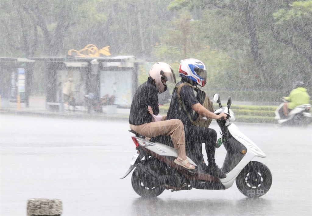 A scooter rider travels in a downpour in Kaohsiung Tuesday. CNA photo May 24, 2022