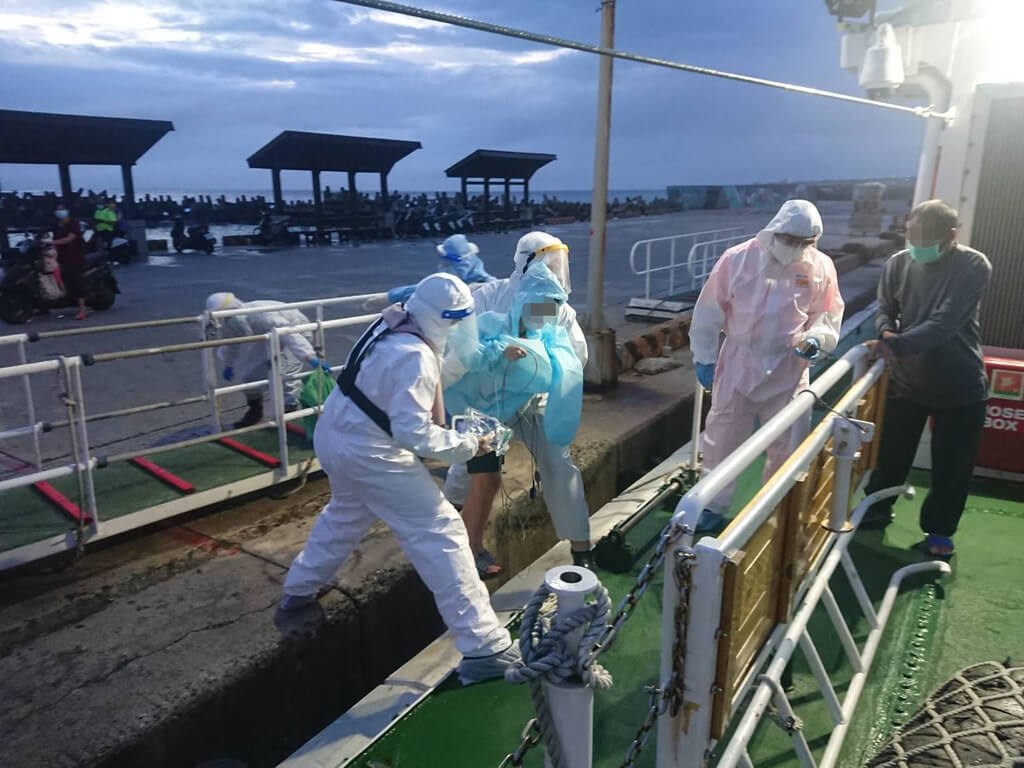 Coast Guard officers take a 7-year-old boy, who showed signs of severe COVID-19 infections, from Cimei Township to the Tri-Service General Hospital