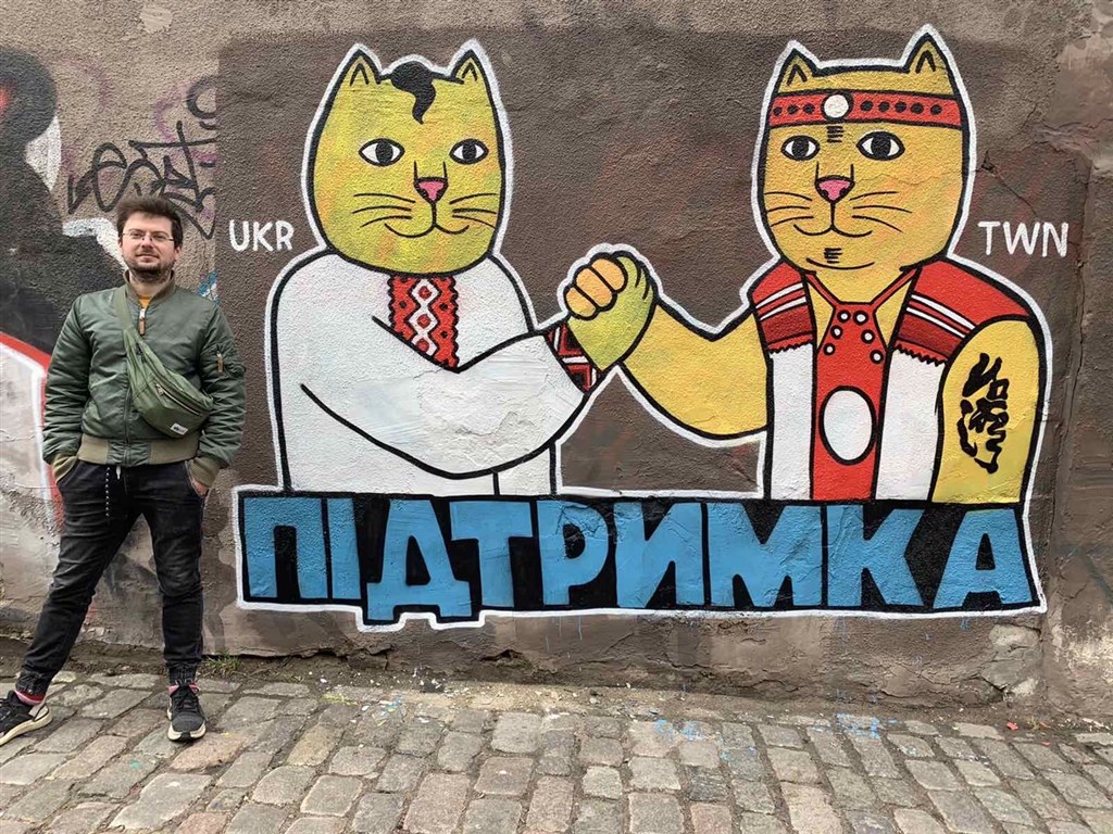Evghen, the man who commissioned the street art, poses next to the two cats that represent friendship between Ukraine and Taiwan. Photo courtesy of Evghen