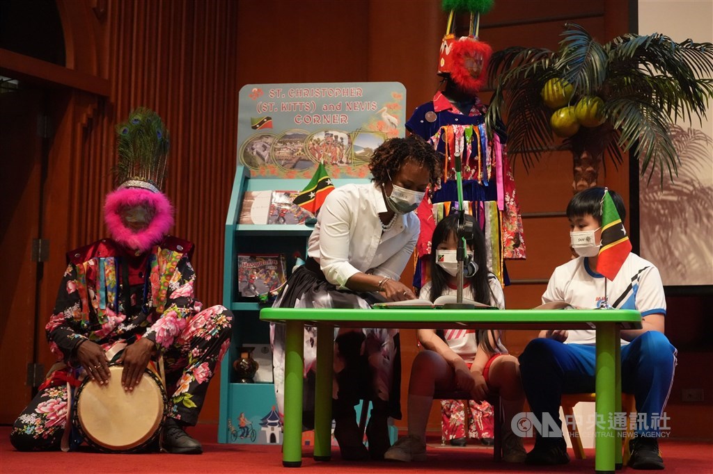 Ambassador Jasmine Elise Huggins (second left) reads Saint Christopher (Saint Kitts) and Nevis children