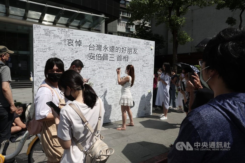 People gather on Sunday in front of a memorial wall set up by the Japan-Taiwan Exchange Association