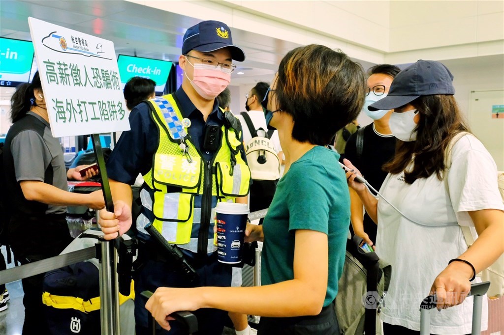 A policeman warns passengers planning to travel to Cambodia at Taiwan Taoyuan International Airport Monday morning. CNA photo Aug. 15, 2022