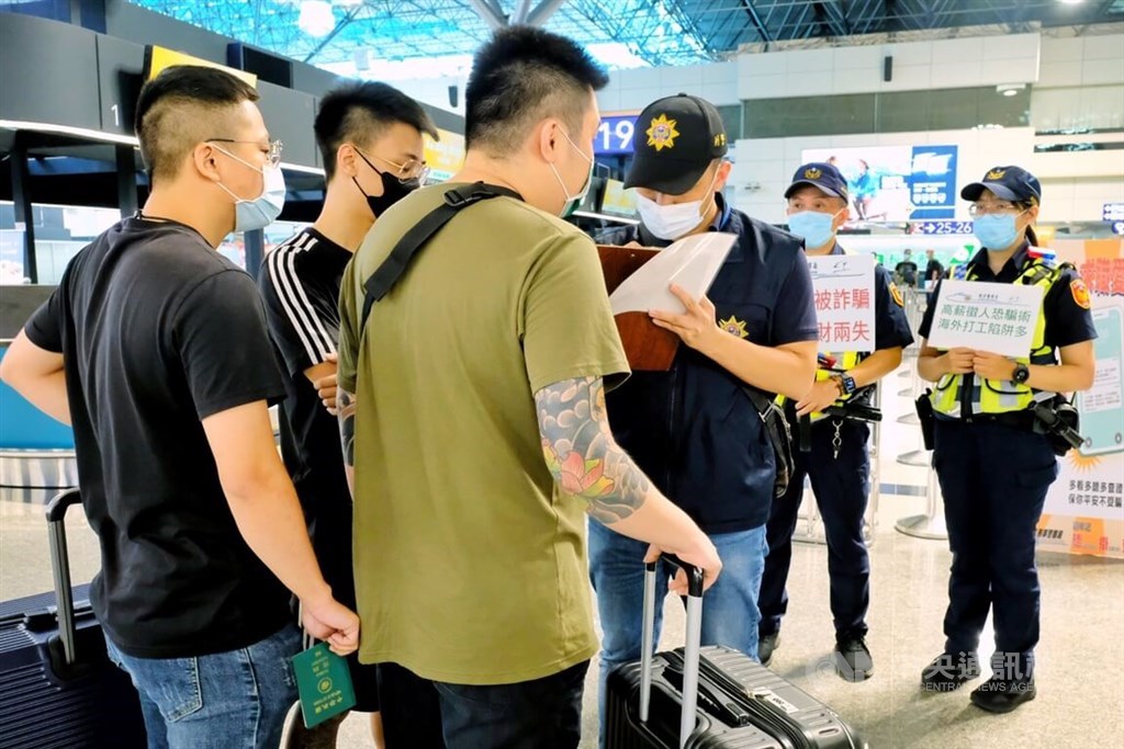 Policemen warn passengers planning to travel to Cambodia about fraudulent job offers at Taiwan Taoyuan International Airport on Monday. CNA photo Aug. 15, 2022