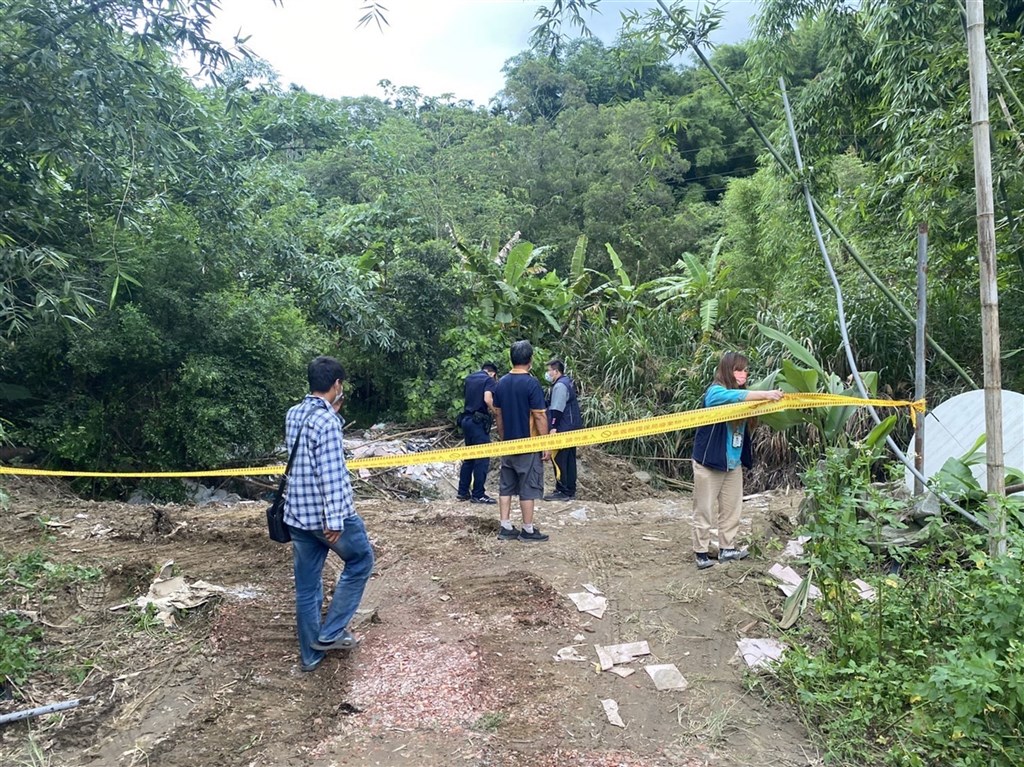 File photo of Chiayi County police examining a site dumped with waste, including building material containing asbestos in June.