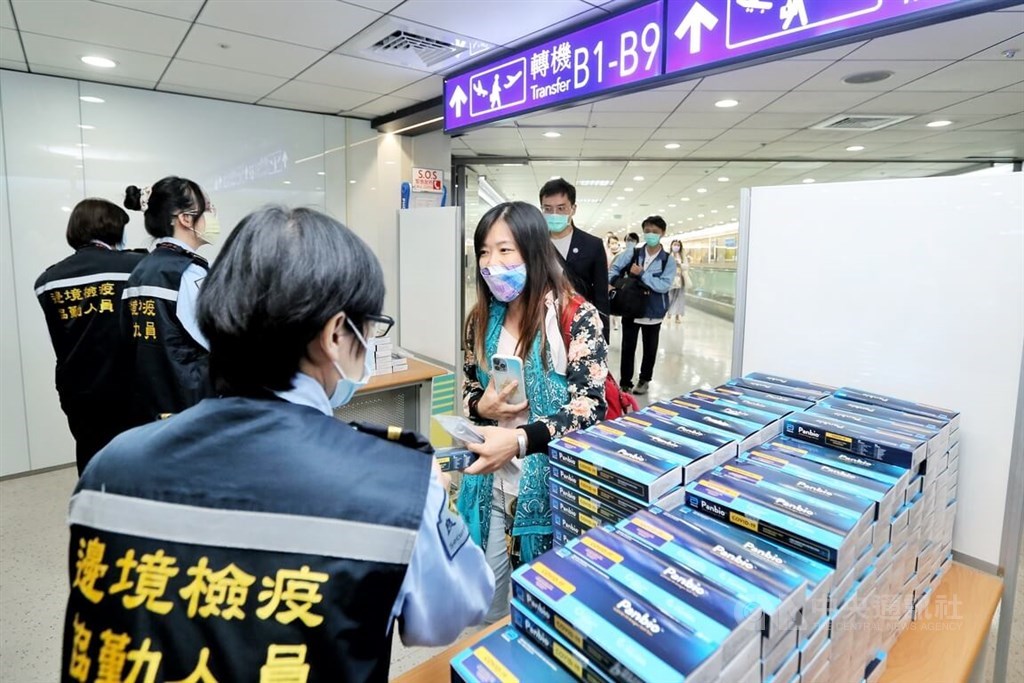 Health workers hand out free rapid test kits to arriving passengers at Taiwan Taoyuan International Airport on Thursday. CNA photo Oct. 13, 2022