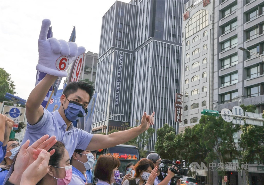 Kuomintang (KMT) candidate Chiang Wan-an (蔣萬安, left), who is running for Taipei mayor, gestures the number "six," his number on the ballot, while campaigning with KMT Taipei City Council candidates near the Zhongxiao Xinsheng MRT Station on Monday. CNA photo Nov. 14, 2022