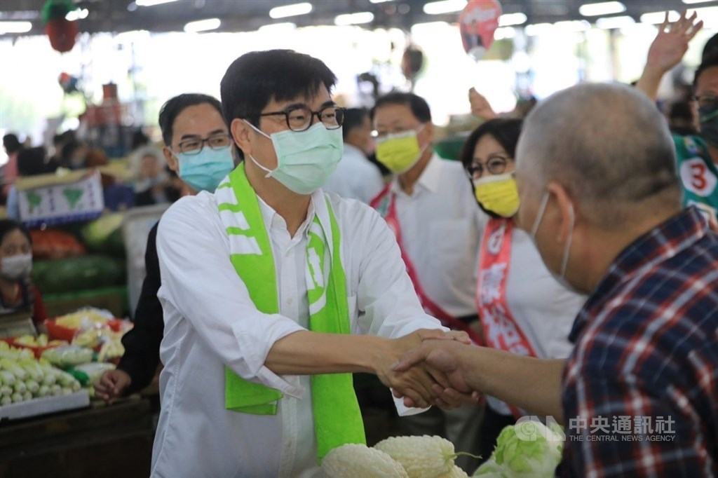 Kaohsiung Mayor Chen Chi-mai (陳其邁), who is running for reelection, shakes hand with a man at a fruit and vegetable market in Sanmin District on Saturday. Photo courtesy of Chen