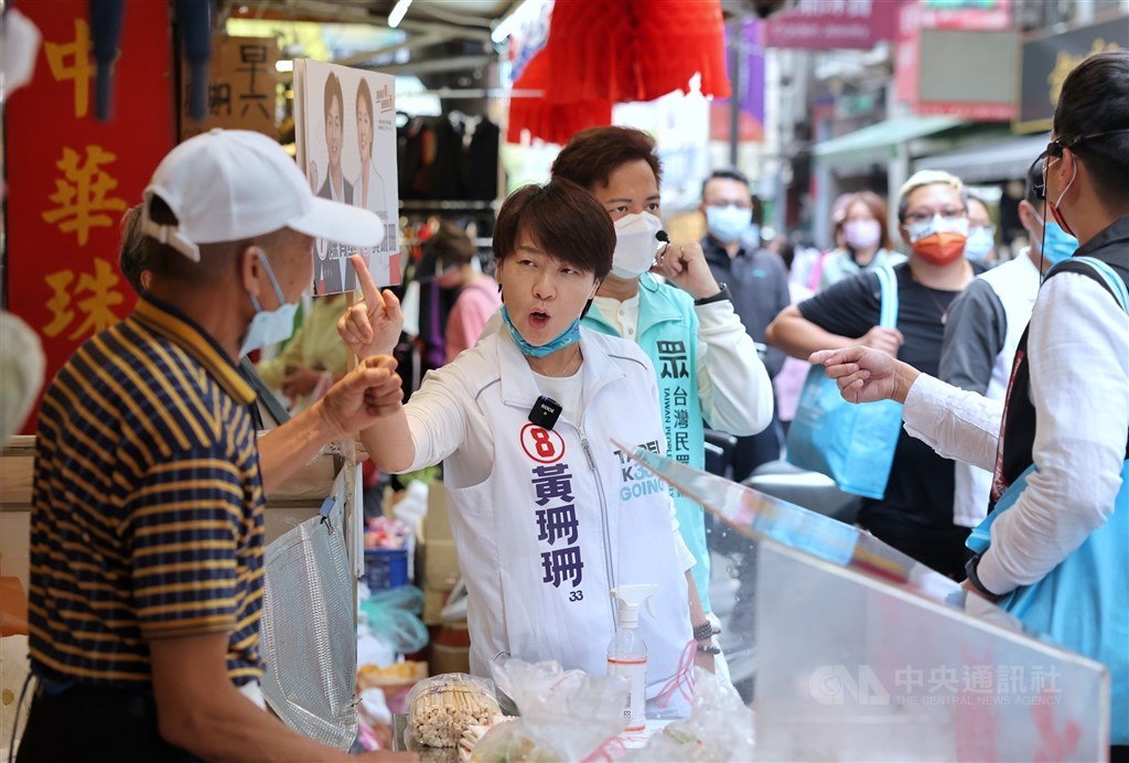Former Deputy Taipei Mayor and independent mayoral candidate in the capital city Huang Shan-shan (黃珊珊) interacts with a vendor while campaigning in the city